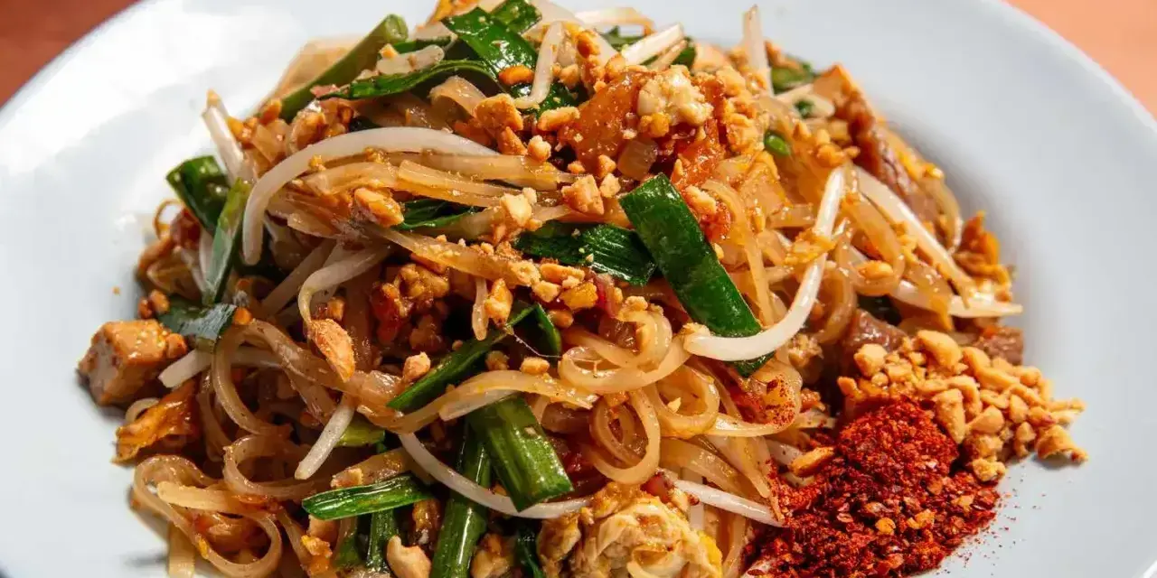 Pyszny pad thai z ryżowym makaronem, kiełkami, orzeszkami i chili. Idealny makaron do pad thai to cienki, płaski ryżowy.