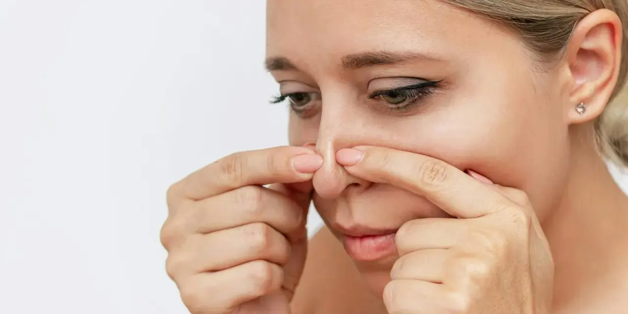 Kvinna undersöker sin näsa, kanske för pormask behandling.
