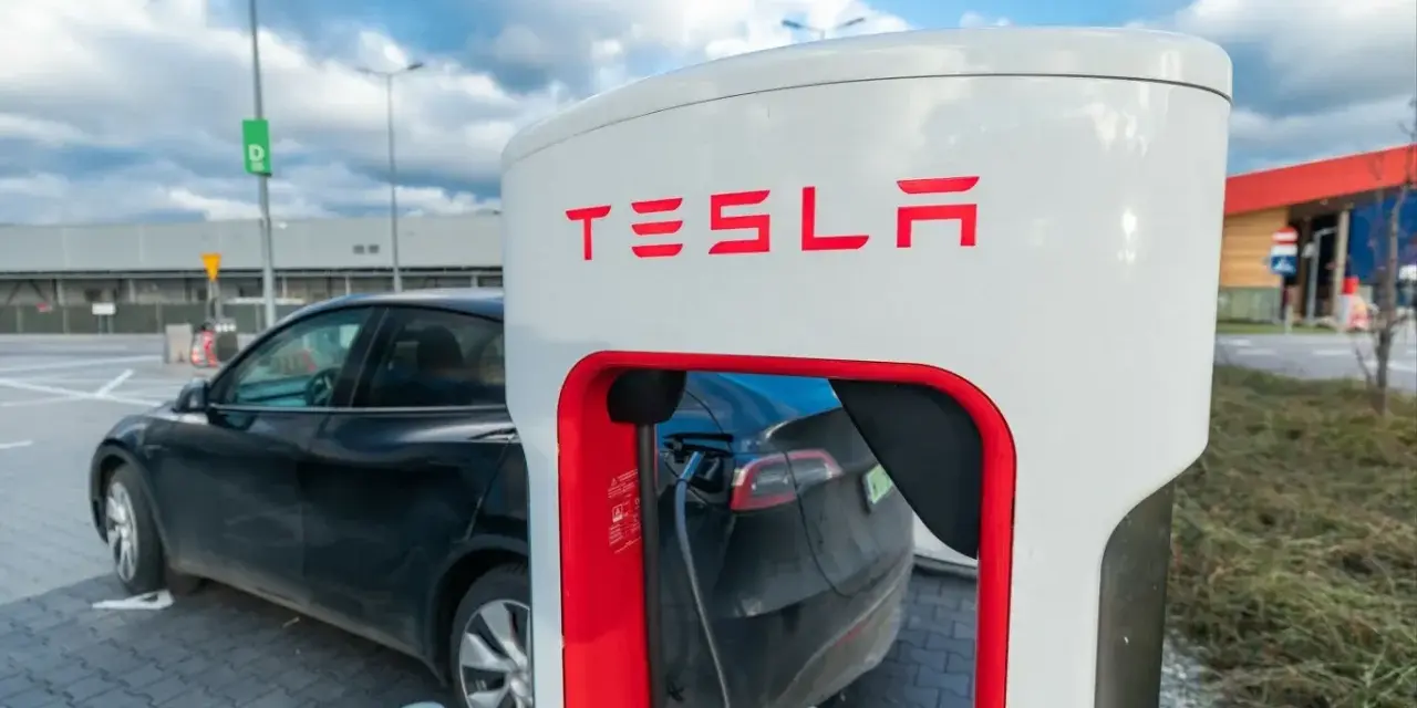 Czarna Tesla podłączona do ładowarki Supercharger.