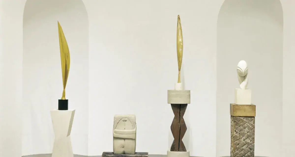 Rzeźby inspirowane twórczością **Constantin Brâncuși**: złoty liść, kamienna postać, drewniany rdzeń i biała głowa.