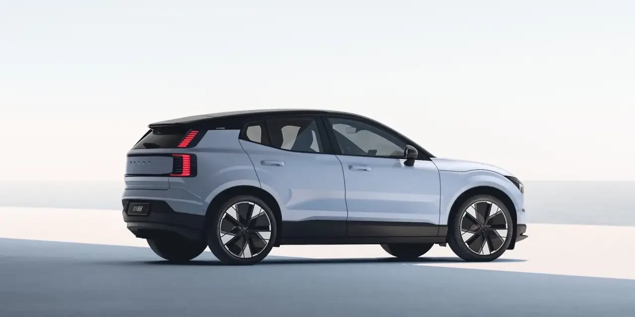 Jasnoszary Volvo EX30 z czarnym dachem i futurystycznymi felgami. Ten elektryczny SUV oferuje imponujący zasięg, idealny na długie podróże.