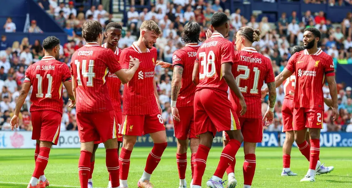 Piłkarze Liverpoolu, mistrzowie Anglii, świętują na boisku. Widać numery 11, 14, 8, 38, 21 i 2.