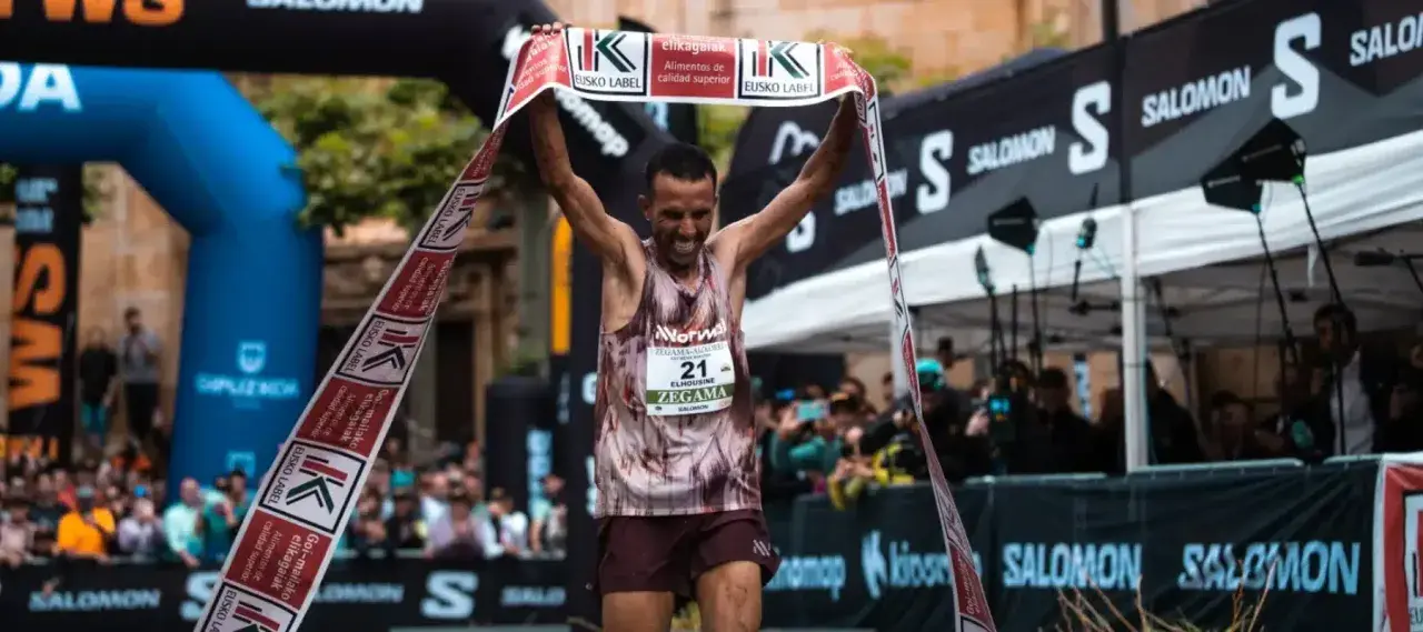 Corredor celebra su victoria en la **Zegama-Aizkorri** rompiendo una cinta.