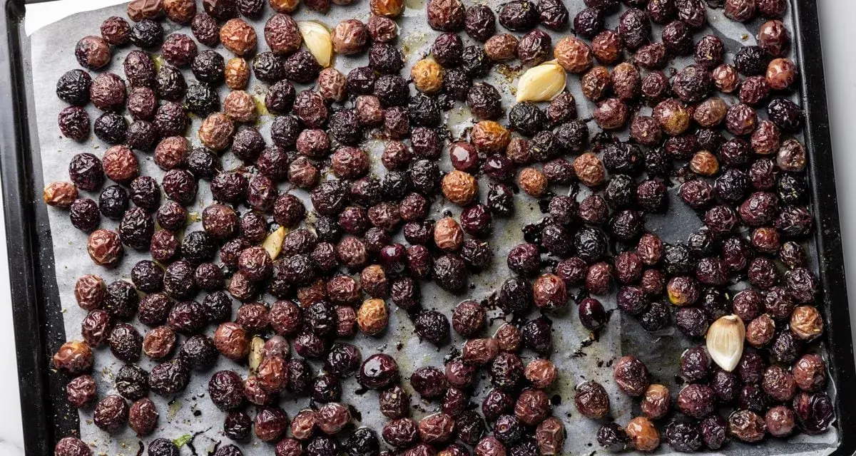 Olive nere al forno alla pugliese, dorate e profumate con aglio, pronte per essere gustate.