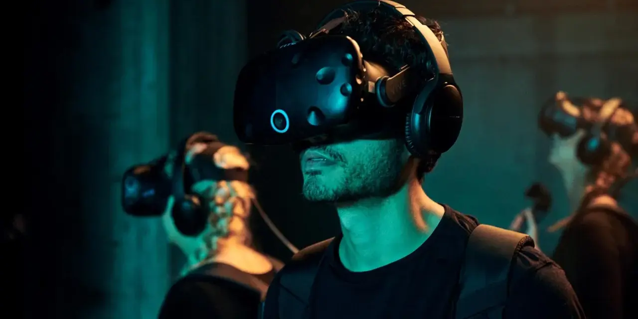 Mann mit VR-Brille bei VR Nation Berlin, taucht in virtuelle Welten ein.
