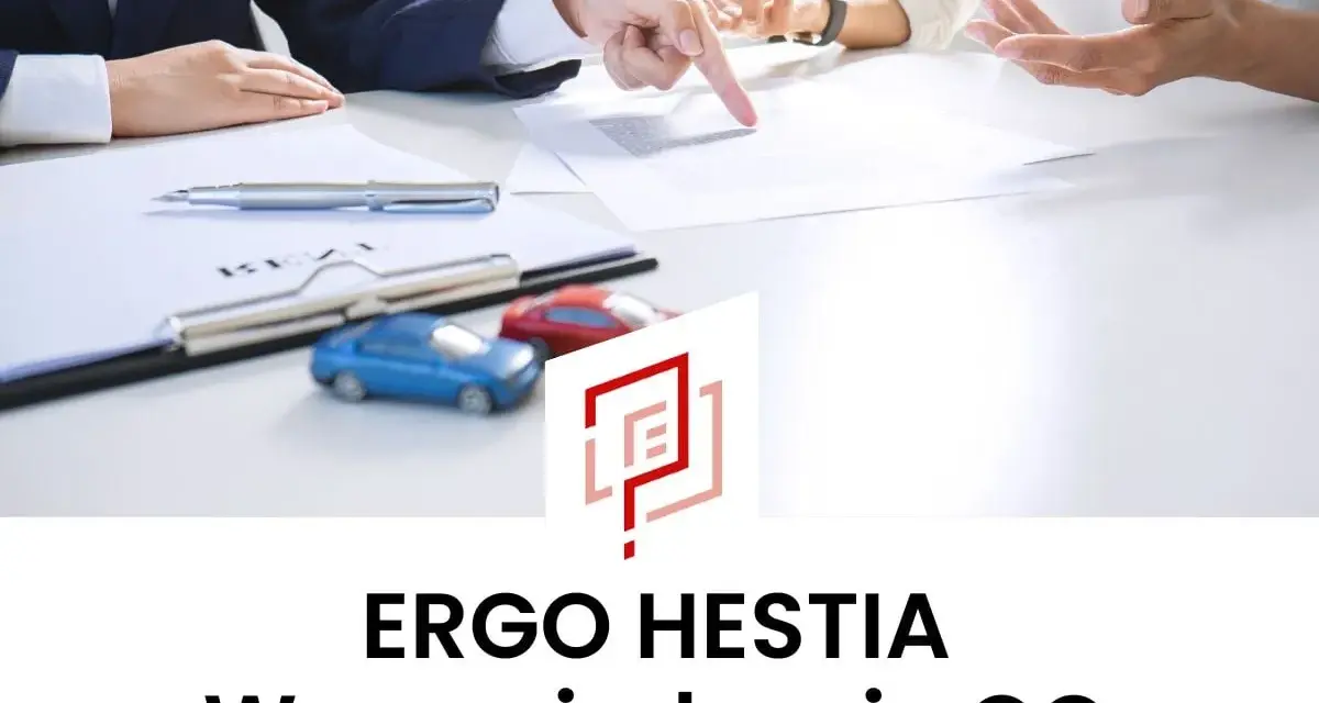 Dwie osoby omawiają dokumenty przy biurku, obok małe modele samochodów.