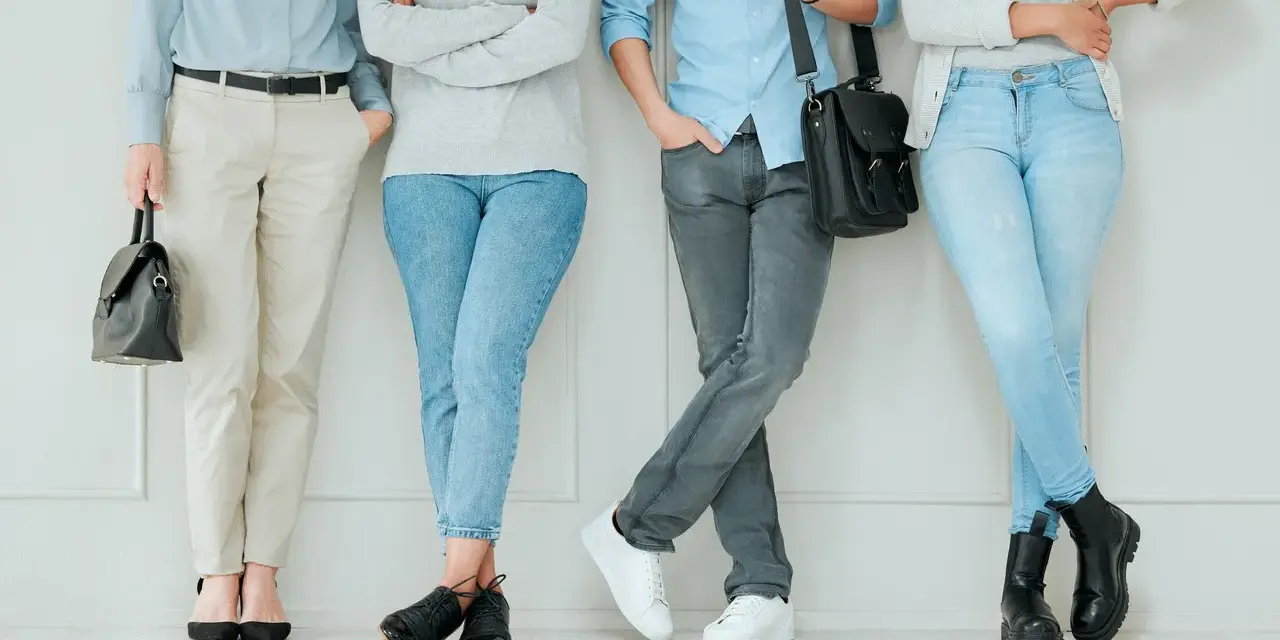 Cztery osoby w casualowych strojach, odzwierciedlające luźny dress code co to. Jasne jeansy, spodnie chino, swetry i koszule.
