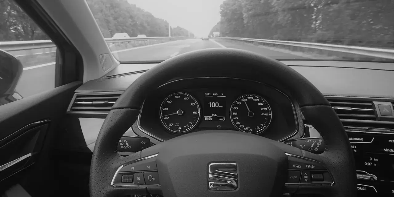 Blick auf das Armaturenbrett eines Autos mit aktiviertem Tempomat. Der Tacho zeigt 100 km/h.