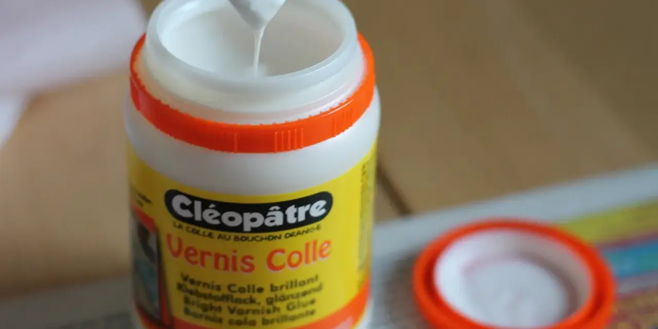 Un pinceau trempe dans un pot de vernis colle Cléopâtre, prêt à protéger une peinture acrylique.