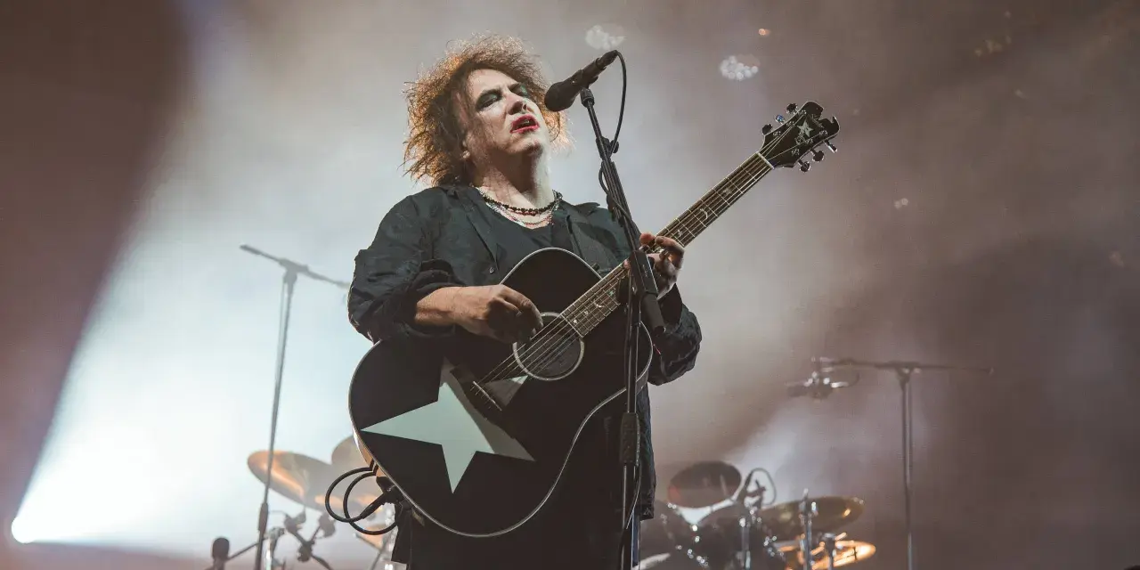 Robert Smith von The Cure spielt auf einer Gitarre mit weißem Stern.