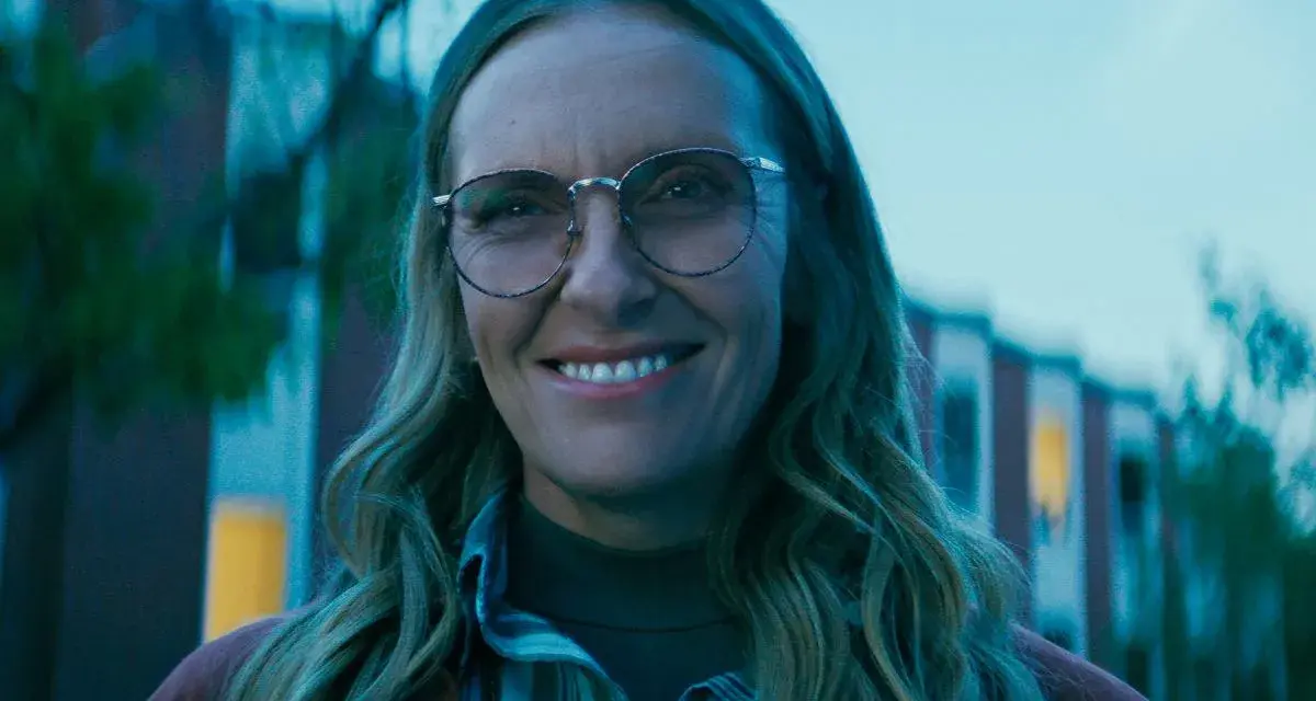 Uśmiechnięta Toni Collette w okularach, znana z wielu filmów i seriali, wygląda na zadowoloną.