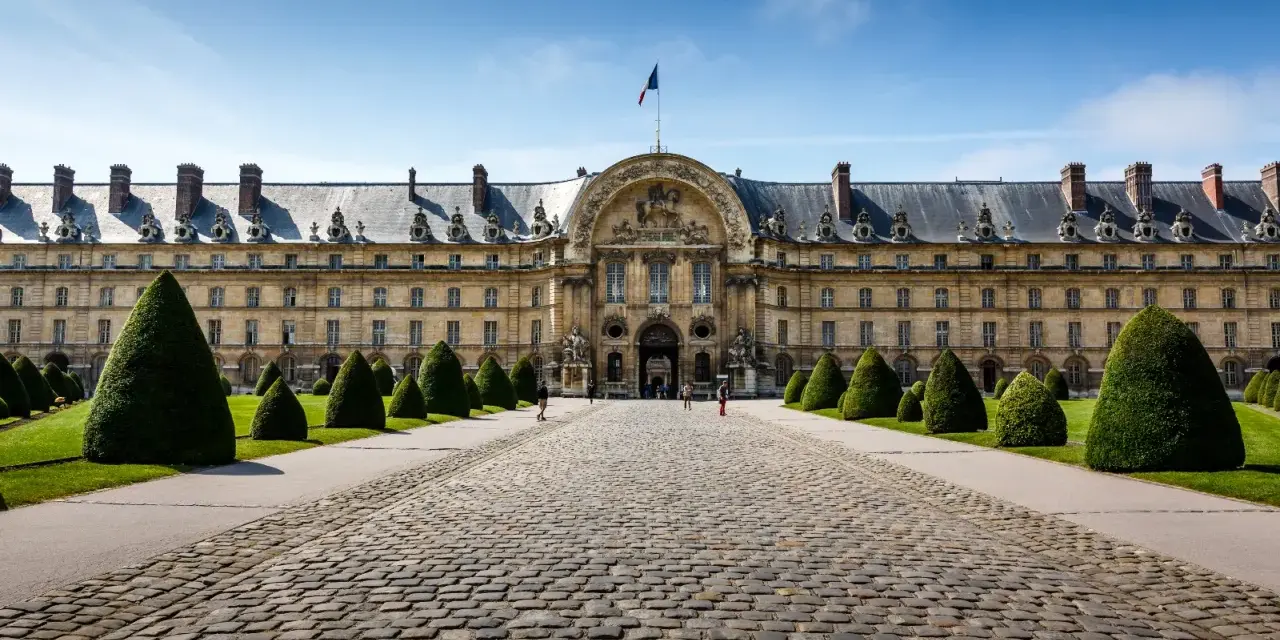 El majestuoso edificio de Les Invalides, donde se encuentra la tumba de Napoleón, con su fachada dorada y jardines cuidados.