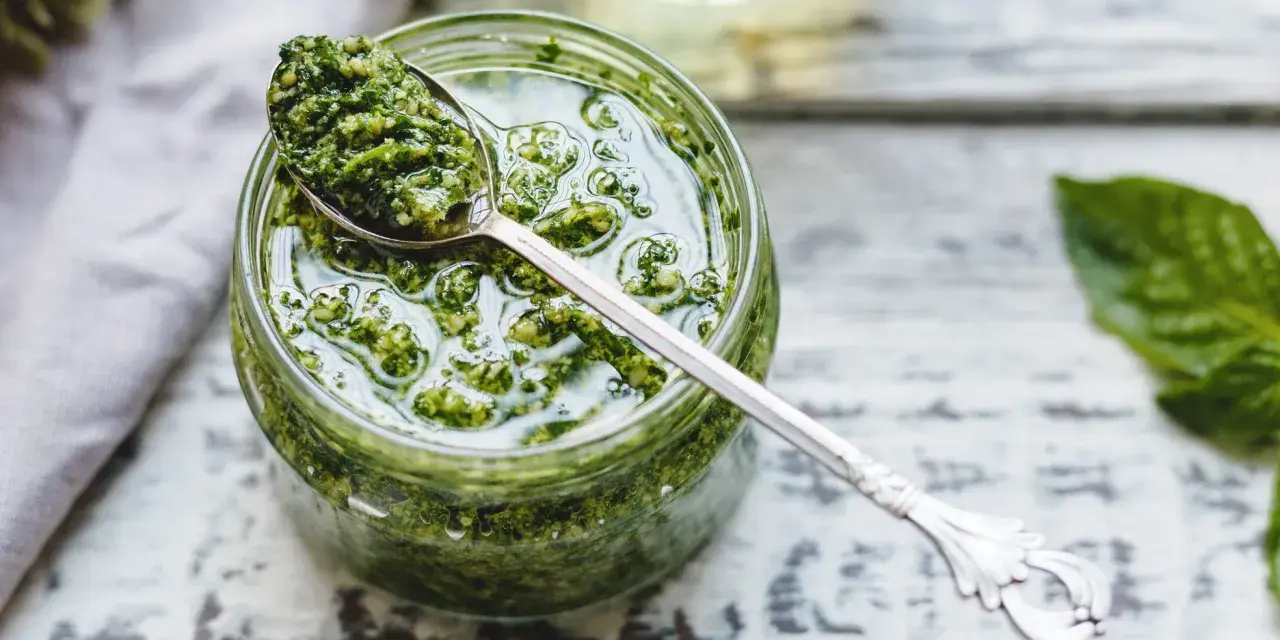 Un cucchiaio di fresco pesto genovese frullatore, pronto per condire la pasta.