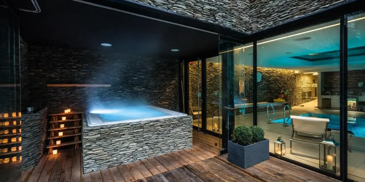 Relaks w nowoczesnym spa na Dolnym Śląsku: jacuzzi z kamienną obudową, basen i nastrojowe oświetlenie.