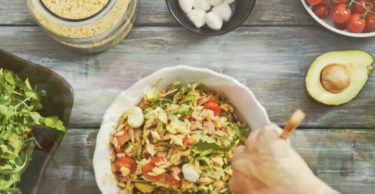 Przygotowanie pysznej sałatki z makaronem orzo z pomidorkami, mozzarellą i rukolą.
