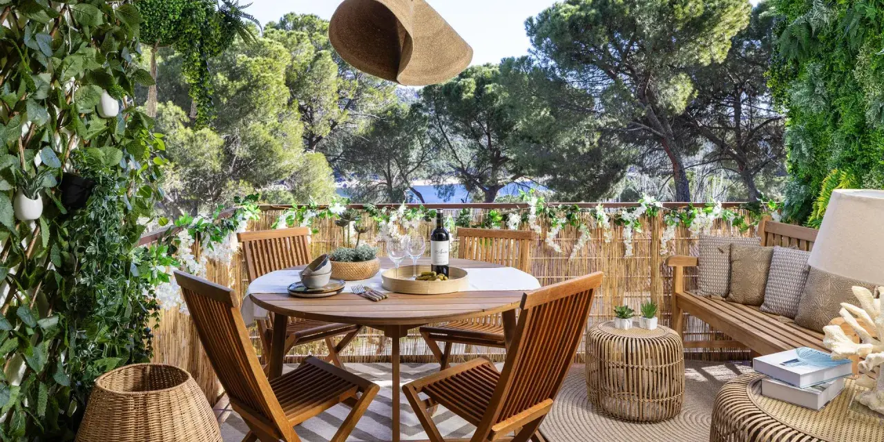 Encantadora decoracion terrazas con mesa de madera, sillas, banco y mucha vegetación. Un oasis verde para disfrutar del aire libre.