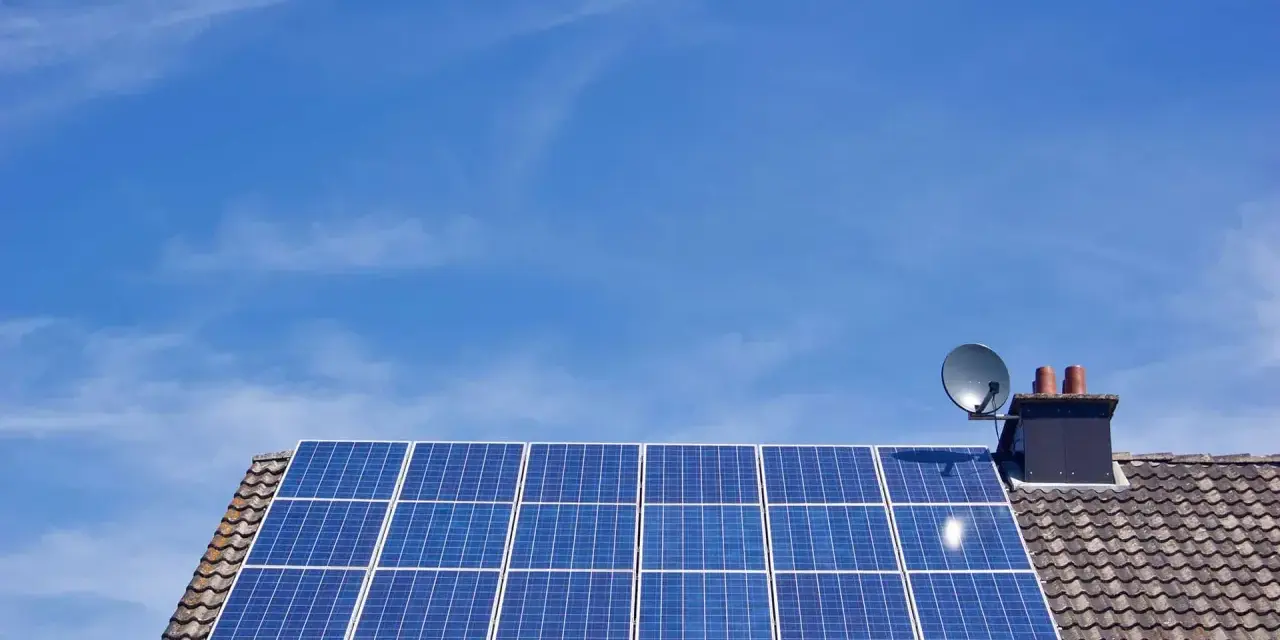 Panele fotowoltaiczne na dachu domu, symbolizujące długą żywotność i ekologiczne pozyskiwanie energii.