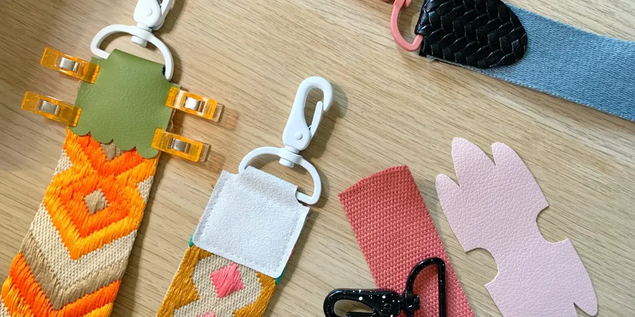 Tuto sangle : plusieurs anses de sacs colorées, avec mousquetons et pièces en cuir, prêtes à être assemblées.