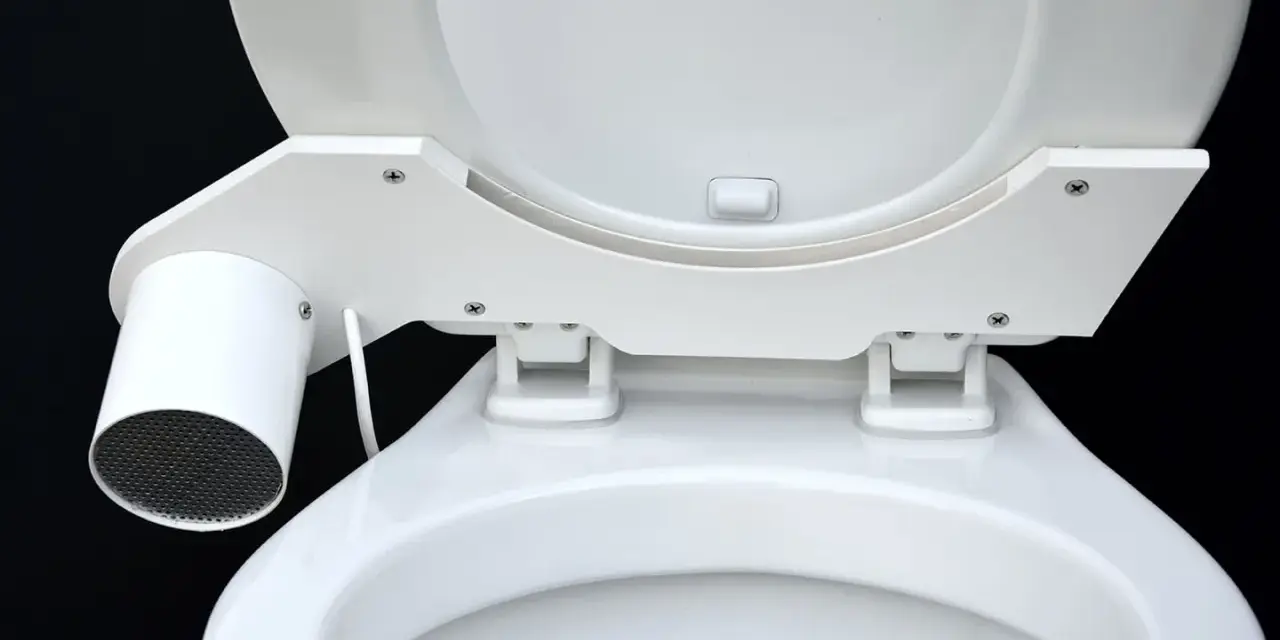 En vit toalett med en innovativ SOG-lösning. En liten cylinder med galler sitter monterad på sidan av sitsen.