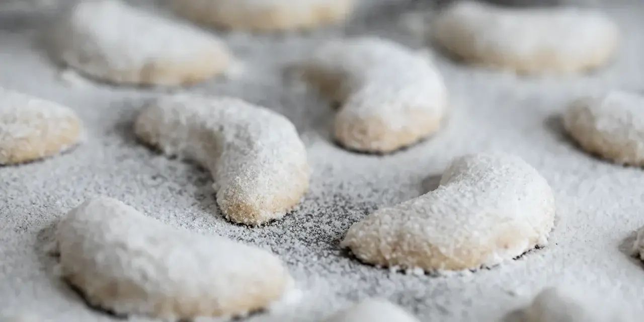 Zarte Vanillekipferl, mit Puderzucker bestäubt, warten darauf, genossen zu werden.
