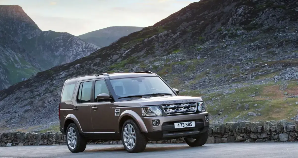 Brązowy Land Rover Discovery 4 na tle górskich krajobrazów. Nawet w tak malowniczym miejscu mogą pojawić się land rover discovery 4 awarie i problemy.