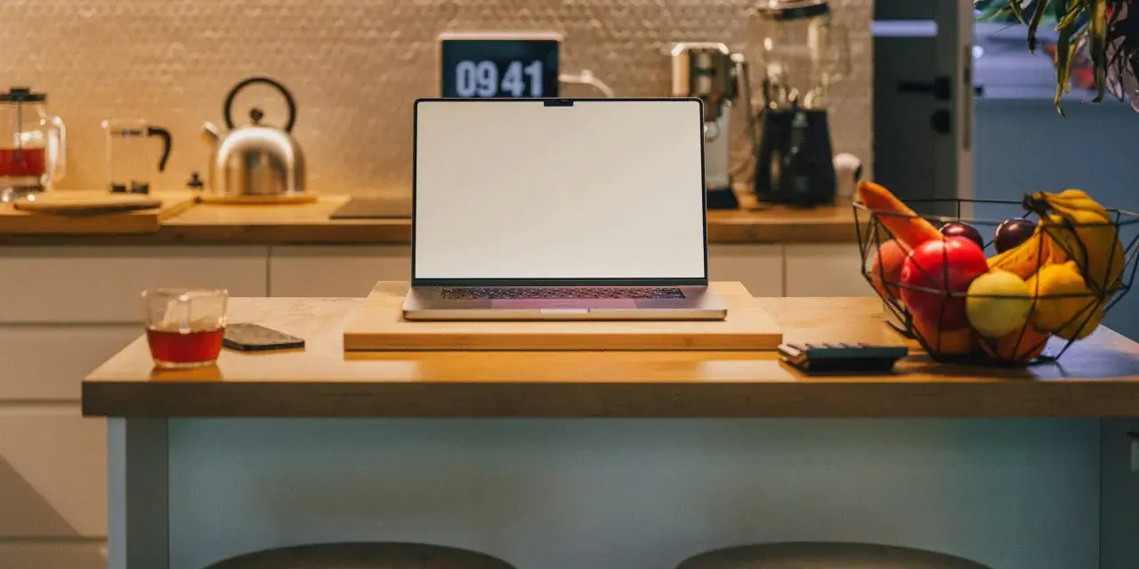 Ein Laptop steht auf einer Küchentheke neben Obst und einem Glas Tee. Vielleicht fragst du dich, was Bixby ist – ein digitaler Assistent, der dir bei vielen Dingen helfen kann.