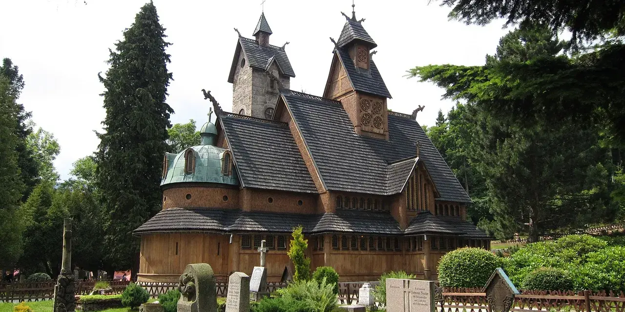 Drewniana świątynia Wang w Karpaczu, otoczona cmentarzem i drzewami. Ciekawostki o jej budowie i historii przyciągają turystów.