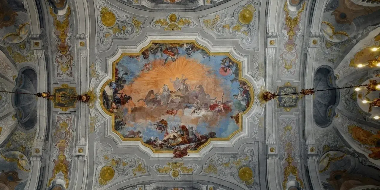 Plafond orné de fresques célestes, un exemple de style **rococo def.**, avec des anges, des chevaux et un soleil éclatant.
