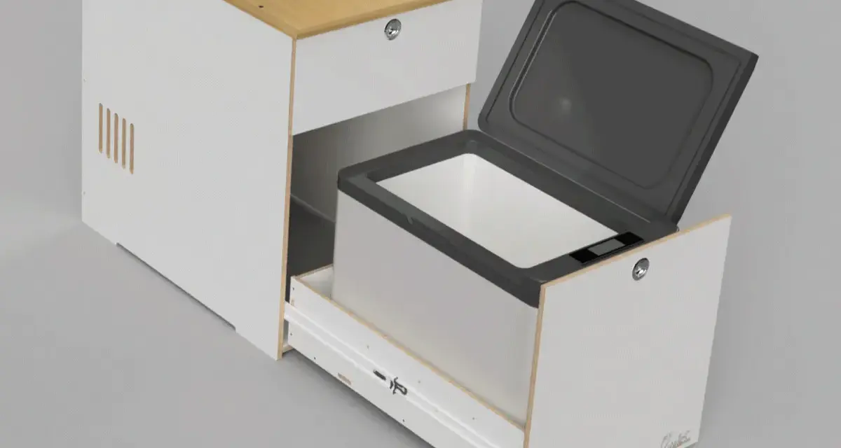 En kylbox med kompressor testas i en vit möbel med trädetaljer. Locket är öppet och lådan är utdragen.