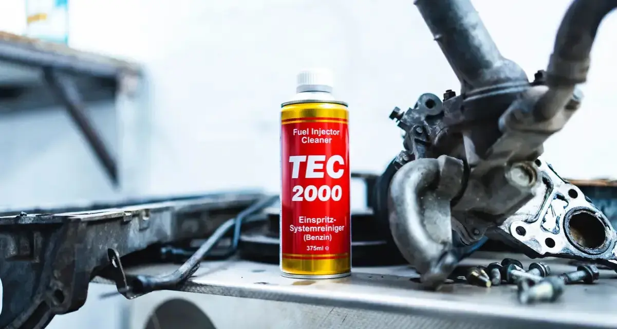 TEC 2000 płukanka do wtryskiwaczy obok rozebranego silnika.