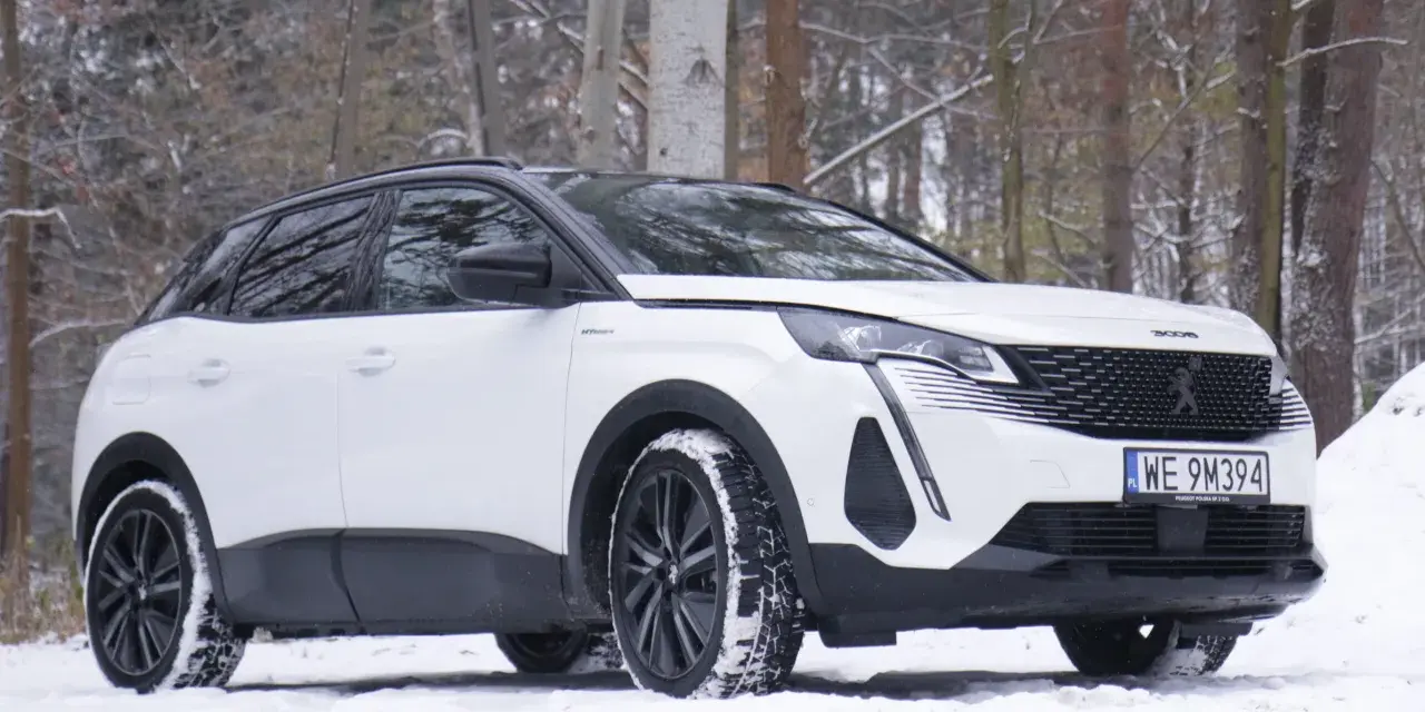 Biały Peugeot 3008 hybryda na śniegu, gotowy na zimowe przygody w lesie.