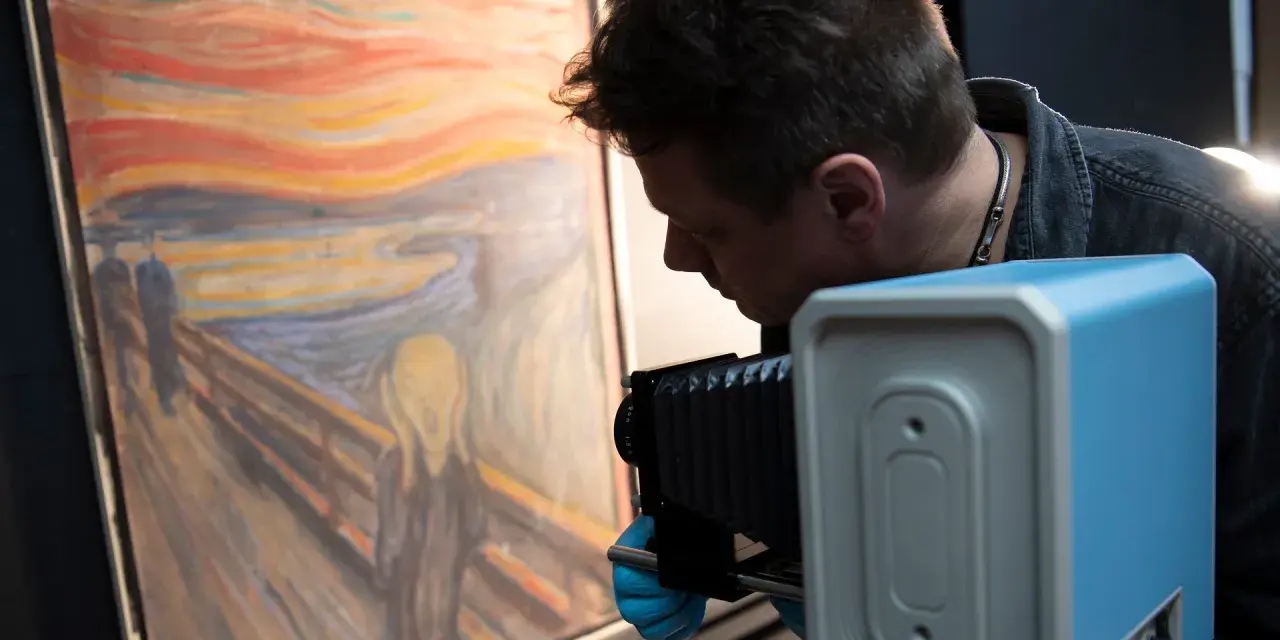 En man med blå handskar fotograferar "Skriet". Vem har målat skriet? Edvard Munch.