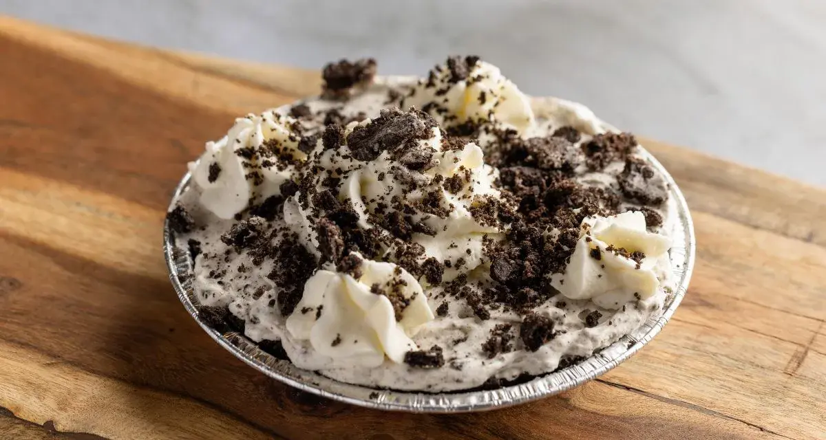 Pyszna masa oreo do tortu, udekorowana bitą śmietaną i pokruszonymi ciasteczkami. Idealna na deser!