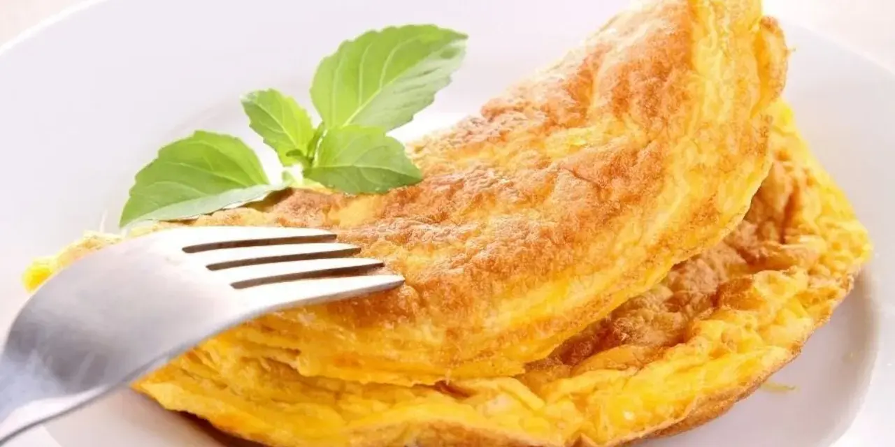 Puszysty omlet z piekarnika, złocisty i lekki, z gałązką bazylii. Idealny na śniadanie.