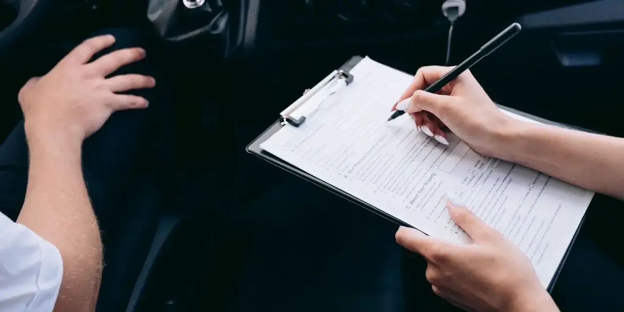 Kobieta wypełnia formularz rejestracji auta, siedząc obok kierowcy.