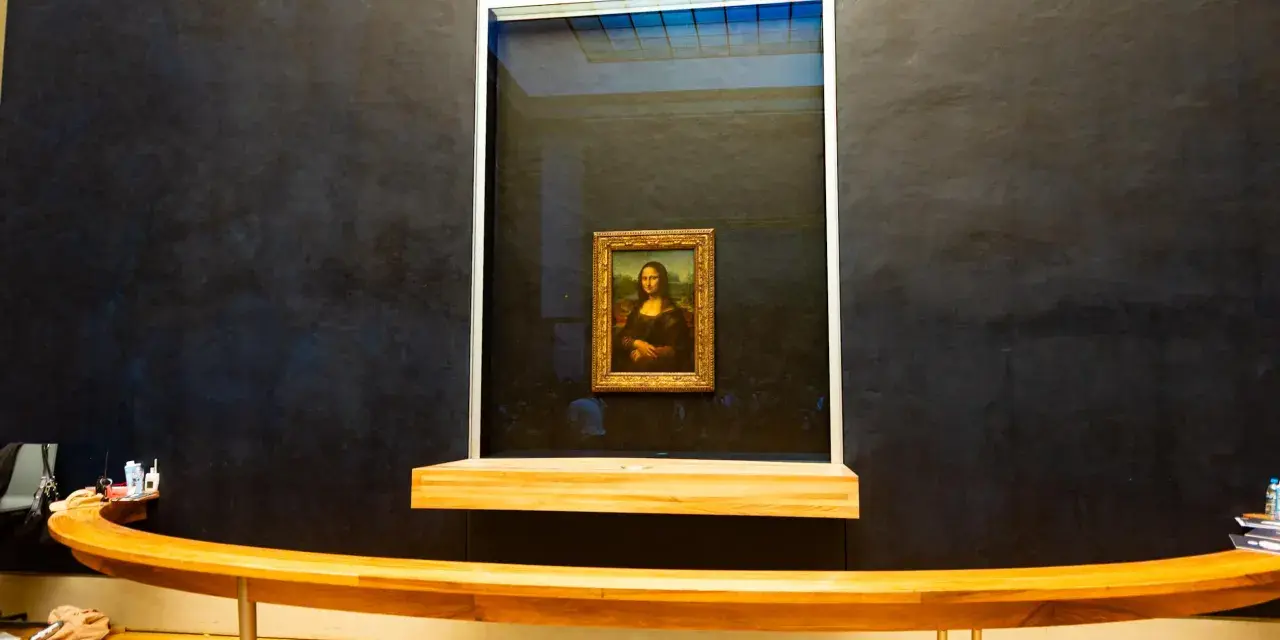 Mona Lisa w muzeum, za pancerną szybą. Słynny obraz Leonarda da Vinci przyciąga tłumy zwiedzających.