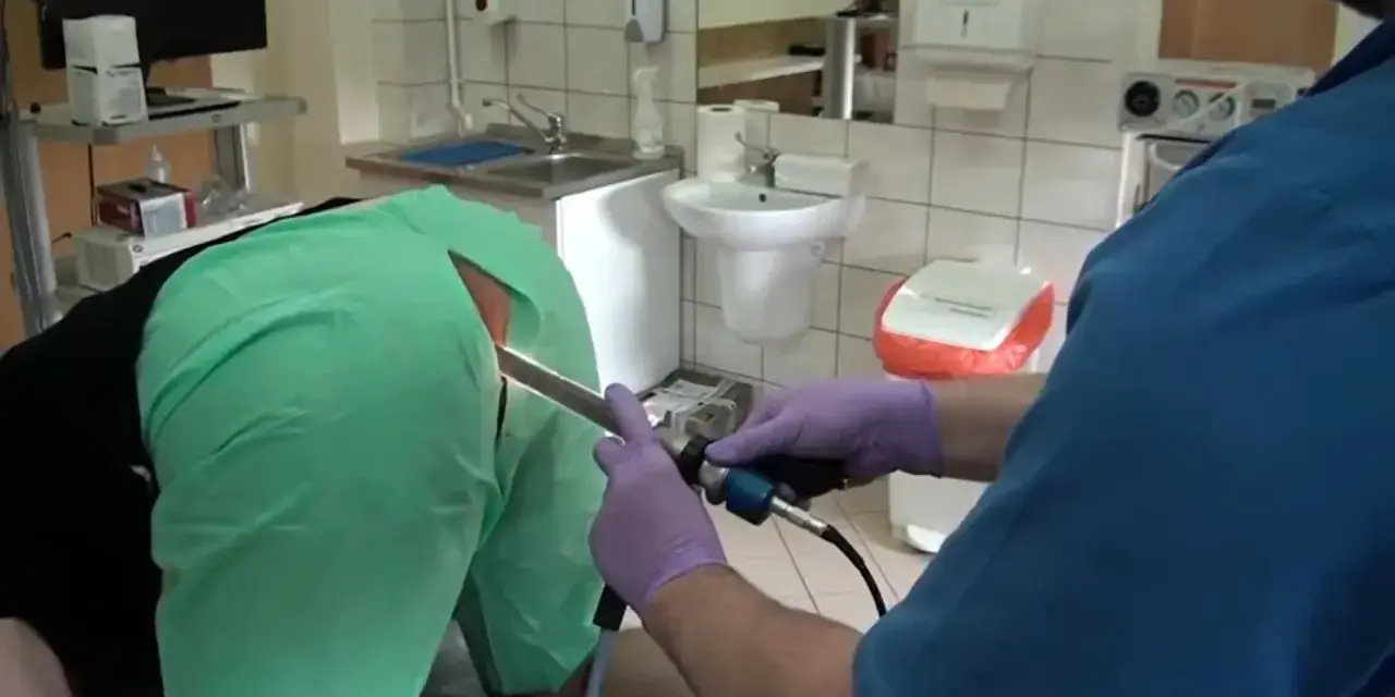 Lekarz w rękawiczkach wykonuje badanie jelit za pomocą endoskopu.
