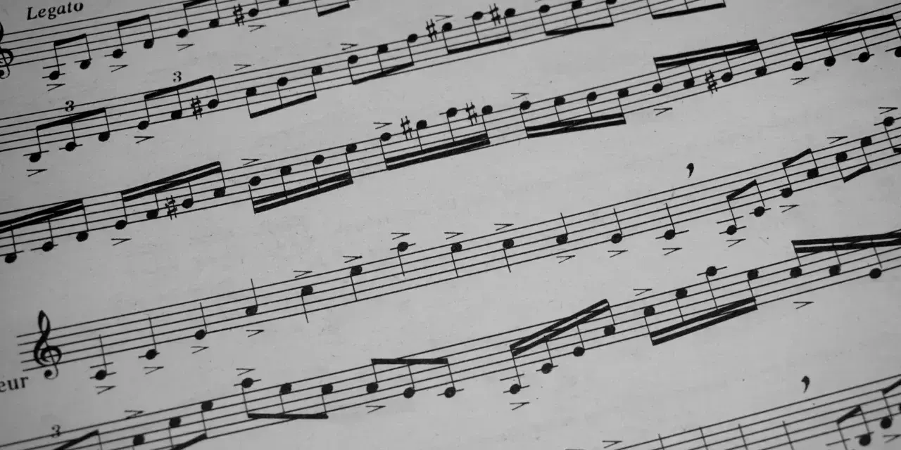Fragment nutowy z zaznaczonym "Legato" i cyframi "3" nad grupami nut, typowy takt 2/4 przykład.
