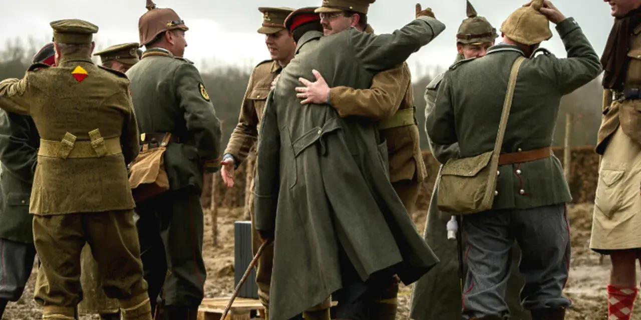 Des soldats en uniforme s'embrassent, une scène évoquant la trêve de Noël 1914.