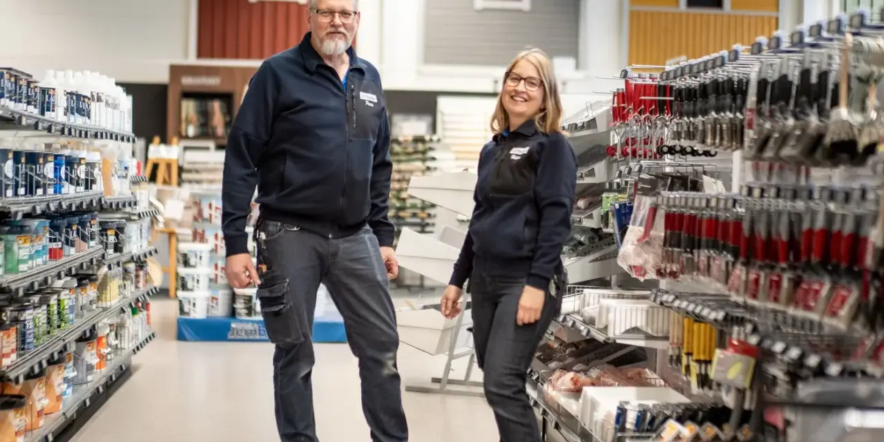 Två anställda står i en butik med färg och verktyg. De hjälper dig gärna att välja rätt färg för att måla fasad.