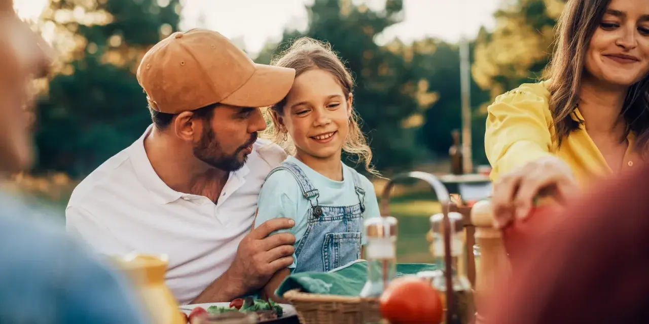 Ein Vater baut eine enge Bindung zu seiner Tochter auf, während sie im Freien speisen.