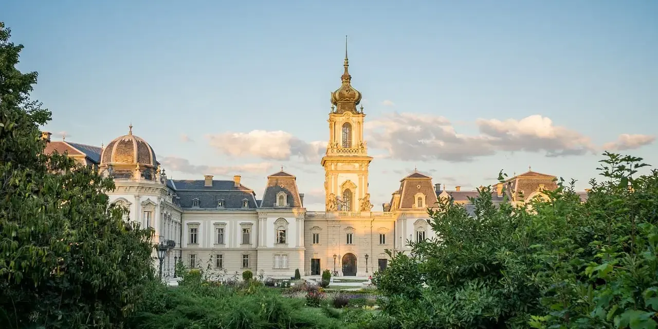 Wspaniały pałac, jak z baśni o królu i królowej, otoczony bujną zielenią. Wieża wznosi się ku niebu, a złote kopuły lśnią w słońcu.