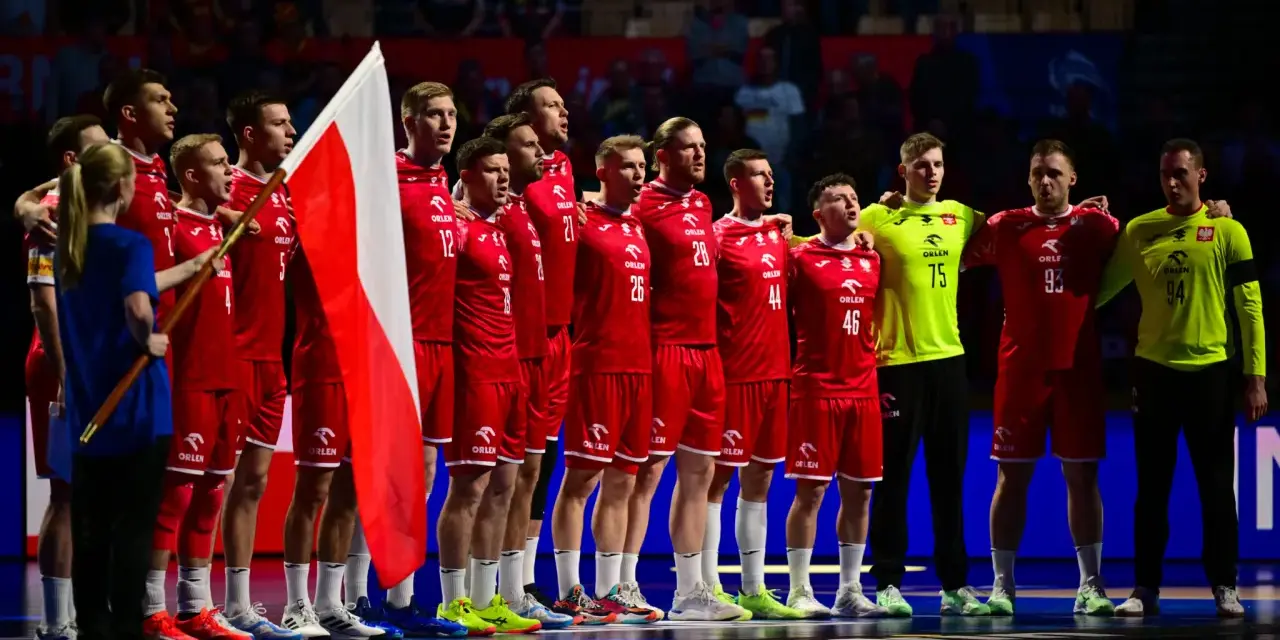 Drużyna piłkarzy ręcznych w czerwonych strojach z polską flagą. To ważny moment w 2 lidze piłki ręcznej.