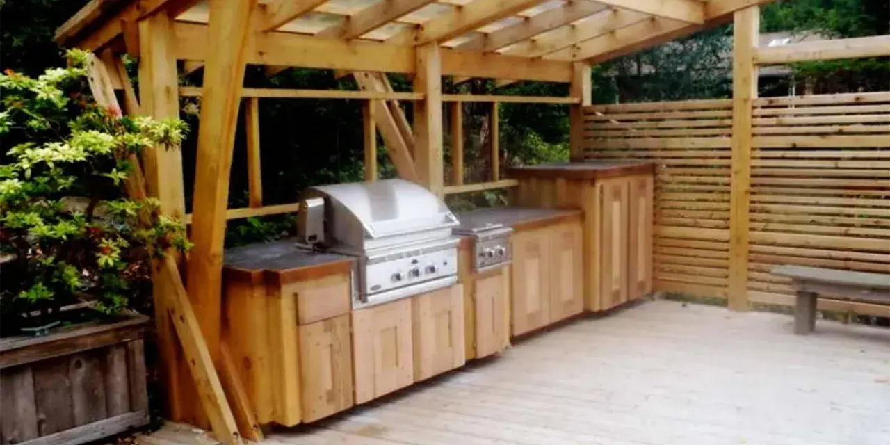 En vacker trägrillplats med inbyggd grill och förvaring. Perfekt grillplats inspiration för din uteplats.