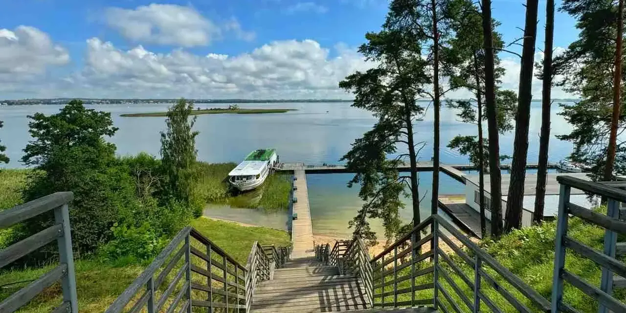 Schody prowadzą do jeziora, gdzie cumuje statek. Idealne miejsce, by zapytać: gdzie na Mazury?