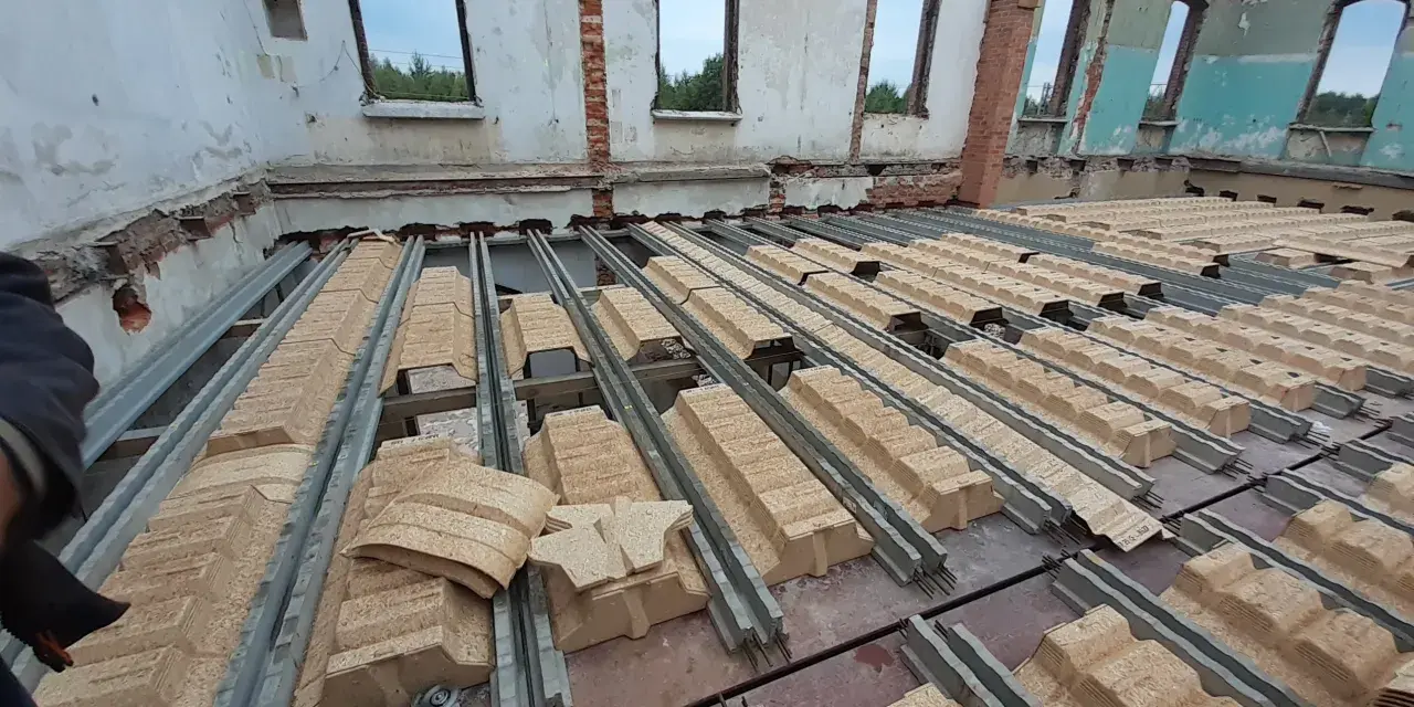 Rozpoczęła się wymiana stropu w starym domu. Metalowe belki i prefabrykowane elementy stropowe czekają na montaż.