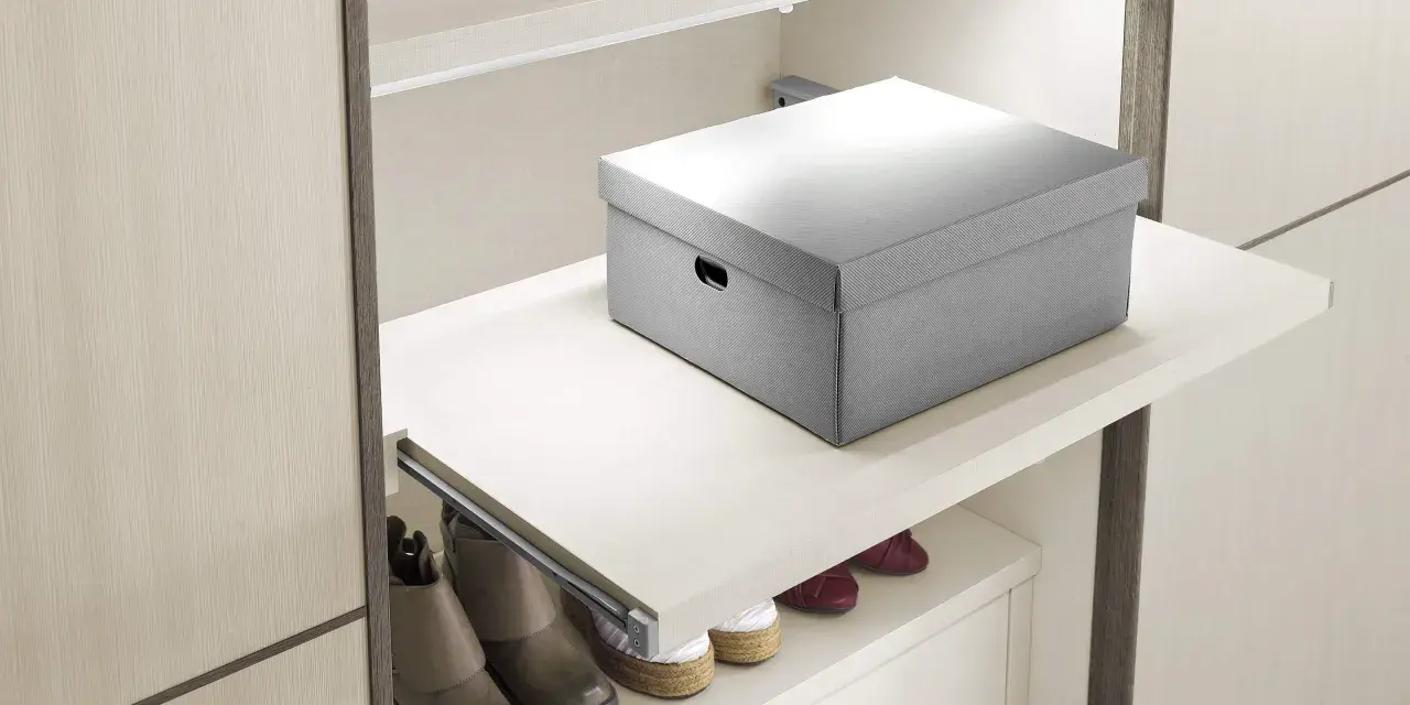Un ripiano estraibile fai da te, con una scatola grigia sopra e scarpe sotto, ottimizza lo spazio in un armadio moderno.