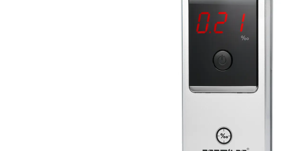 Srebrny alkomat cyfrowy z wyświetlaczem pokazującym wynik 0.21‰.