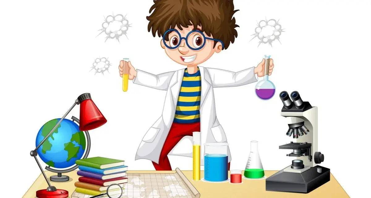 Chłopiec w fartuchu laboratoryjnym z dumą prezentuje swoje **eksperymenty chemiczne dla dzieci**. Na stole stoją probówki, mikroskop i globus.