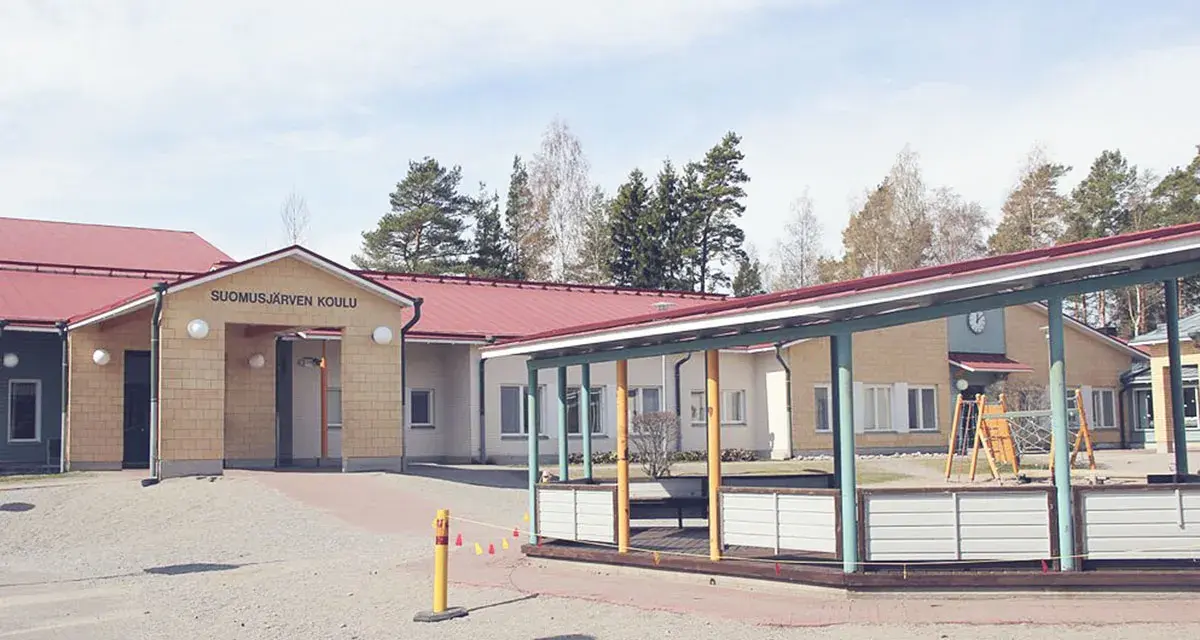 Suomusjärven Koulu, czyli szkoła w Finlandii, z placem zabaw i zielonymi terenami. Ciekawostki o fińskim systemie edukacji często podkreślają jego innowacyjność.